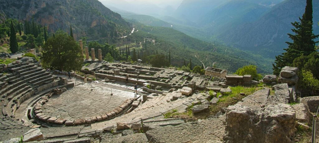 Ruines du Temple d'Apollon à Delphes avec les colonnes doriques et le mont Parnasse en arrière-plan