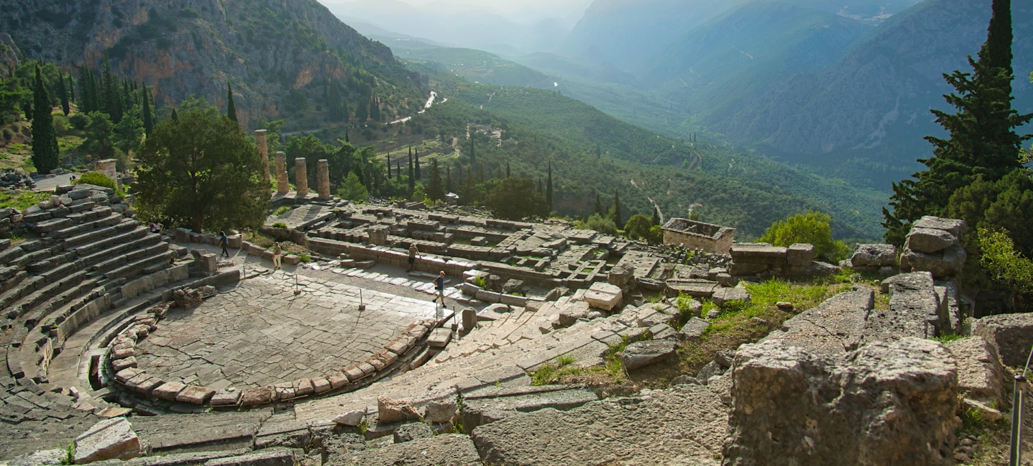 Ruines du Temple d'Apollon à Delphes avec les colonnes doriques et le mont Parnasse en arrière-plan