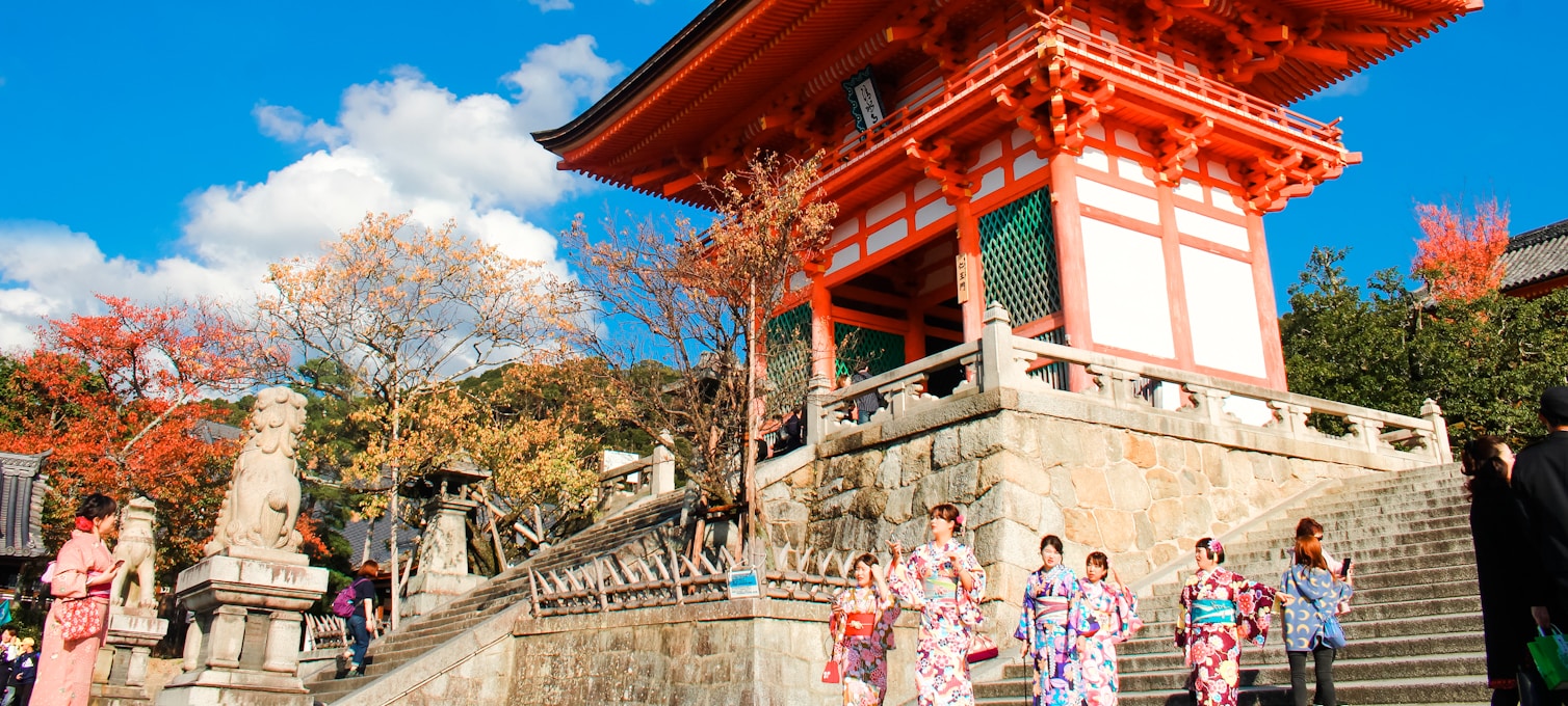 Herbstlaub in Kyoto – rotes und orangefarbenes Blattwerk rund um einen Tempel
