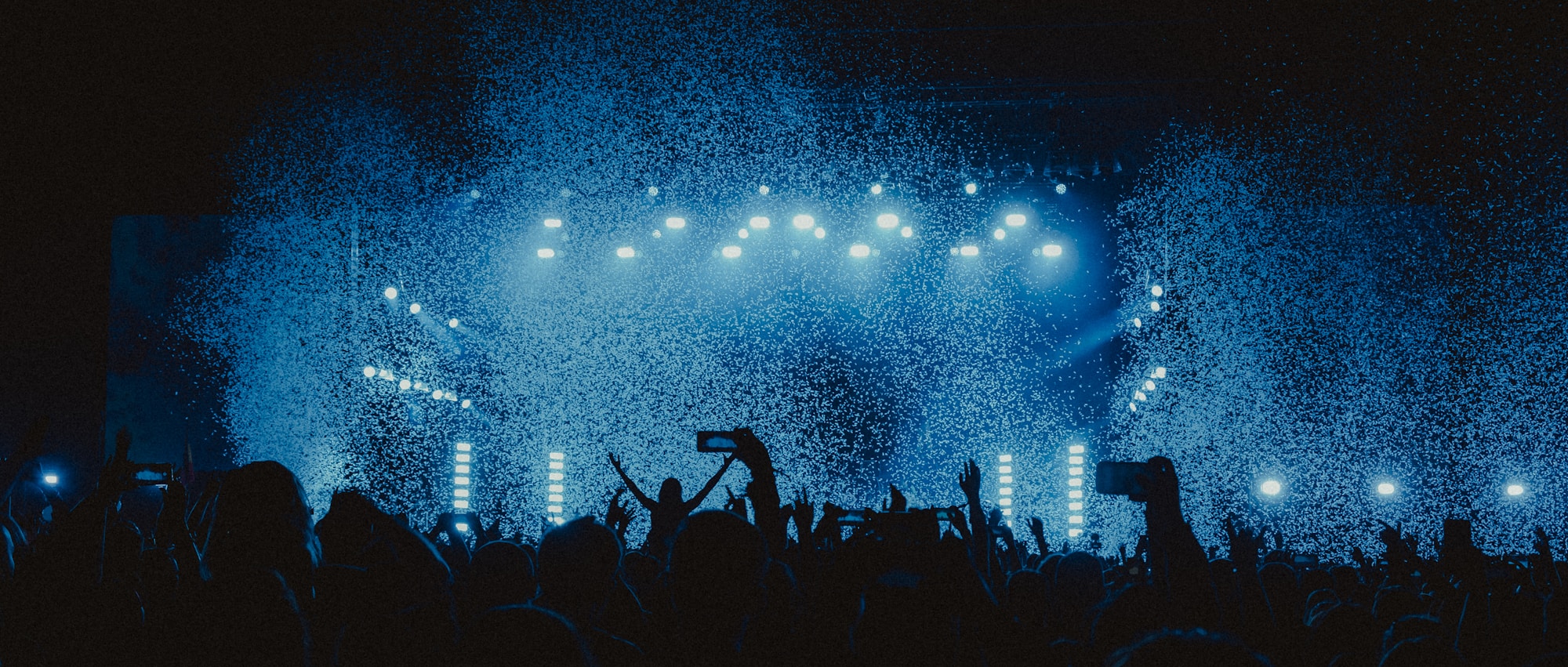 Crowd going wild in front of an illuminated main stage at a summer music festival in Spain