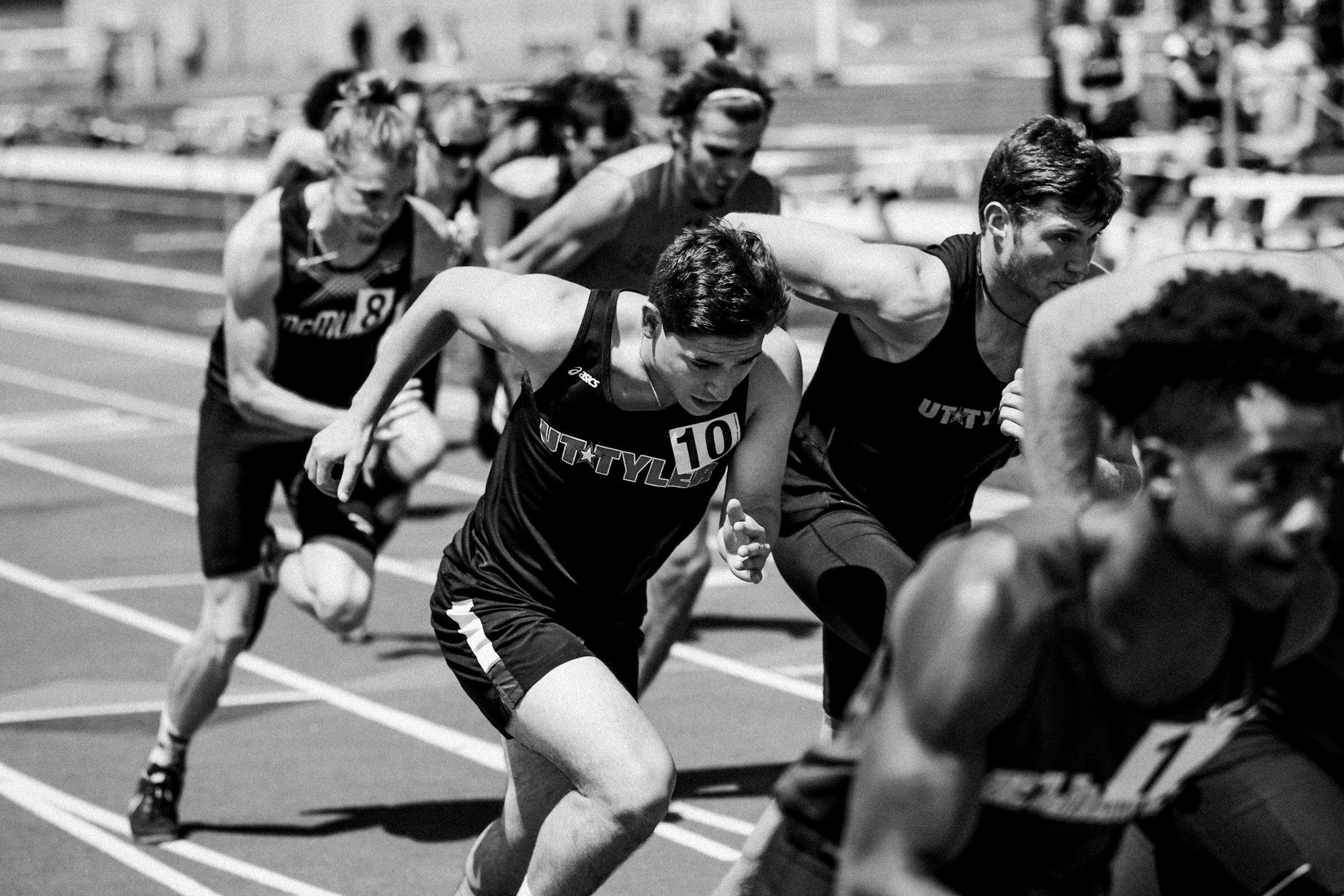 Athleten im Vollsprint auf einer Leichtathletikbahn bei einem internationalen Meeting