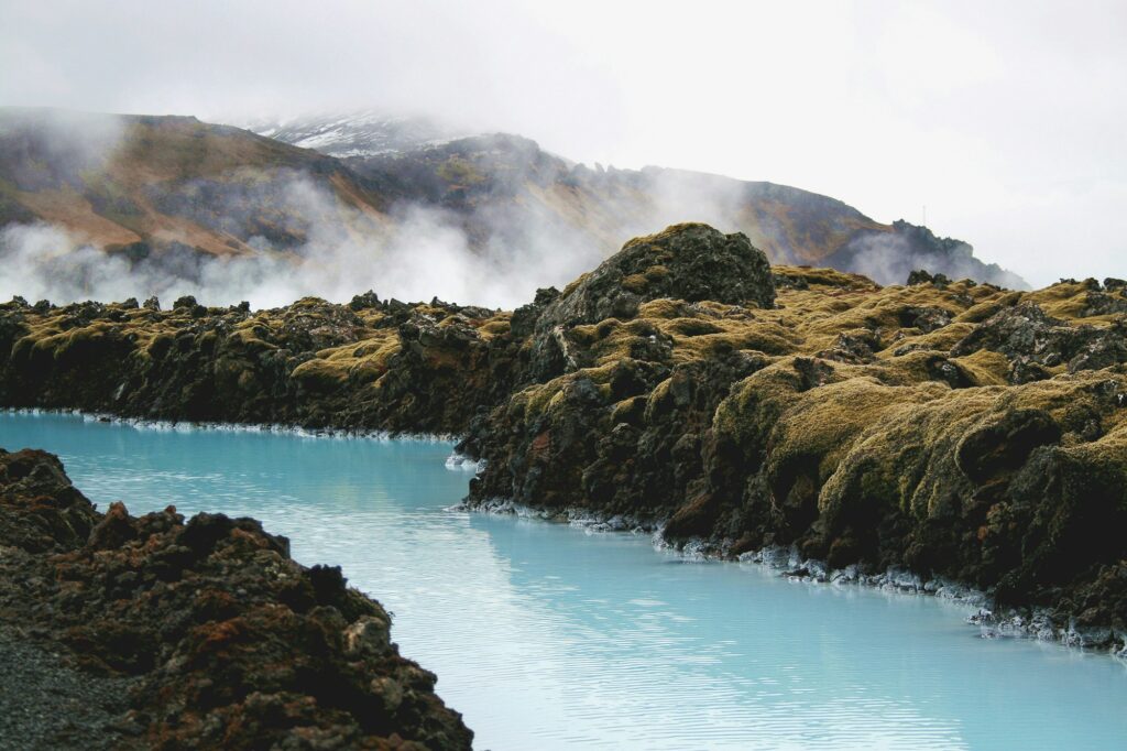 Vapeur s'élevant d'un lagon géothermique islandais dans un paysage de lave noire