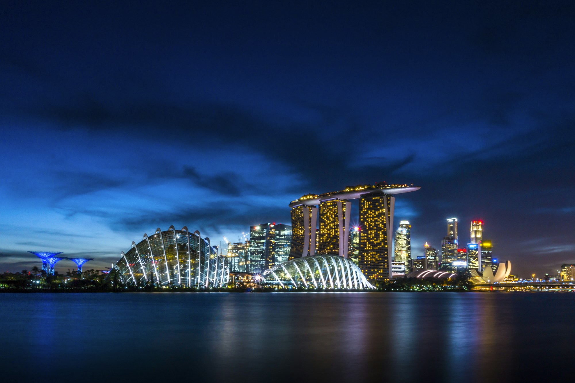 Skyline von Marina Bay bei Nacht mit den Supertrees und den Lichtern der Formel-1-Strecke
