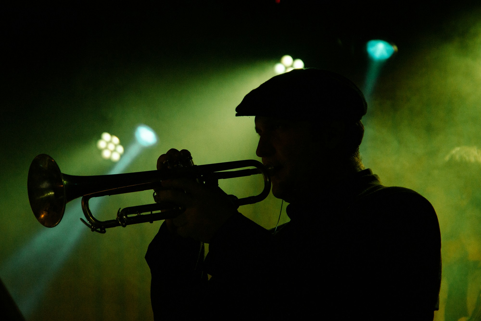 Trompettiste jazz sur scène sous les projecteurs lors d'un concert nocturne en plein air, hommage Miles Davis centenaire