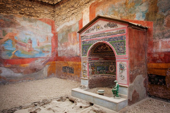 Guide Alex explaining frescoes inside a Pompeii domus during a private tour