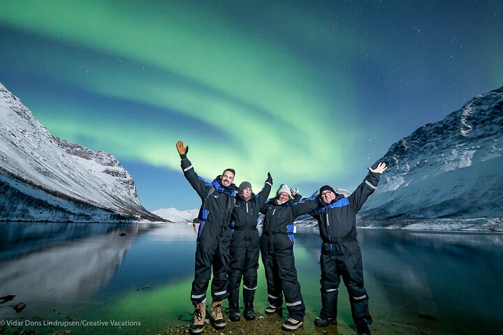 Photographe et groupe sous les aurores boréales à Tromsø, nuit arctique