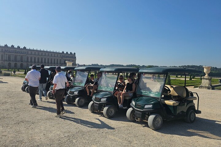 Golfcart et vélos devant les fontaines et jardins de Versailles