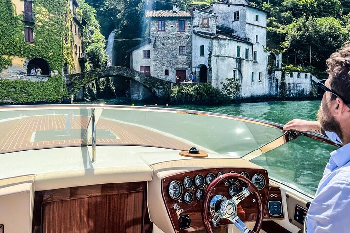 Bateau à moteur classique rouge et blanc sur le lac de Côme devant le quai du Bar Lario