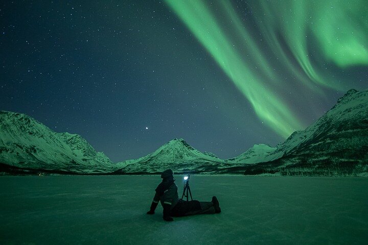 Guide photographe arctique et groupe devant aurores boréales en Norvège
