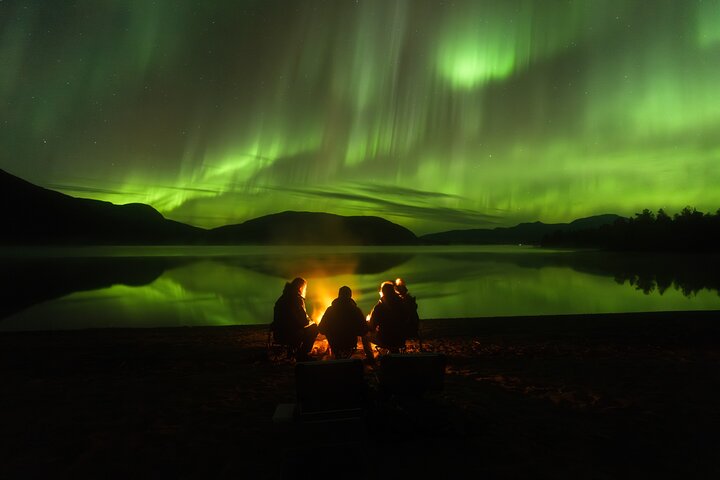 Aurores boréales vertes au-dessus de Tromsø la nuit, petit groupe en extérieur