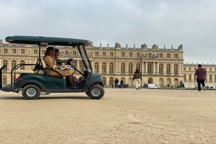 Voiturette de golf électrique devant les jardins du château de Versailles