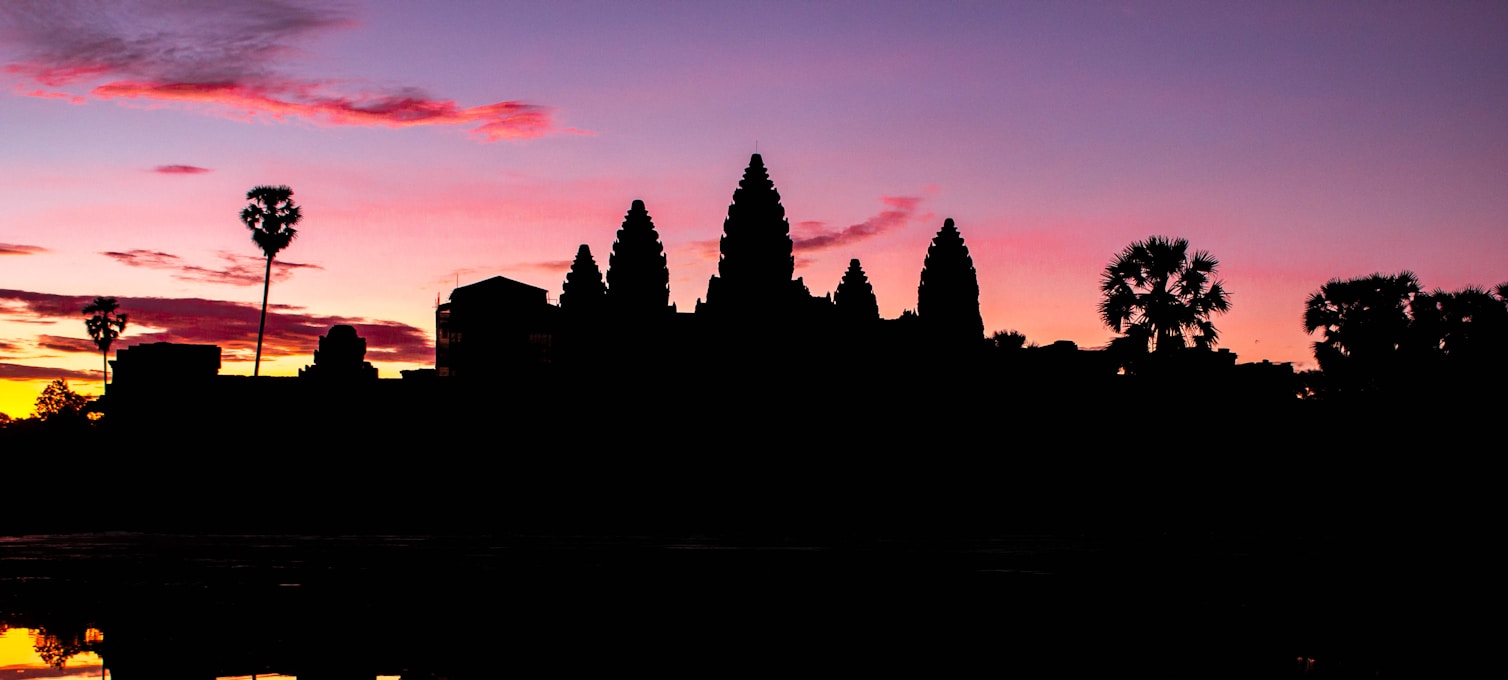 Silhouette des tours d'Angkor Wat au lever du soleil devant les bassins
