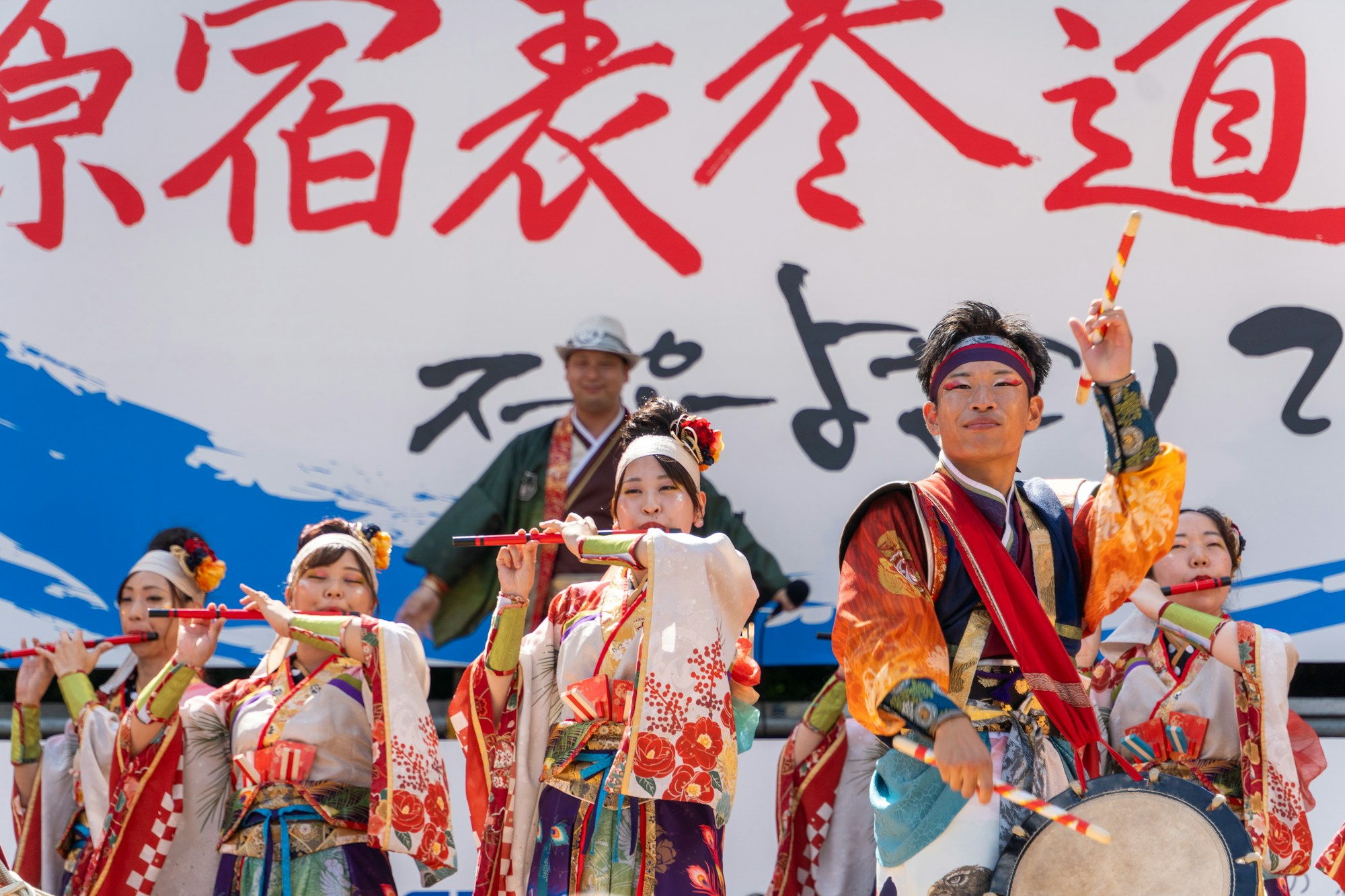 Músicos en kimono tocando el taiko y la flauta en un festival callejero japonés