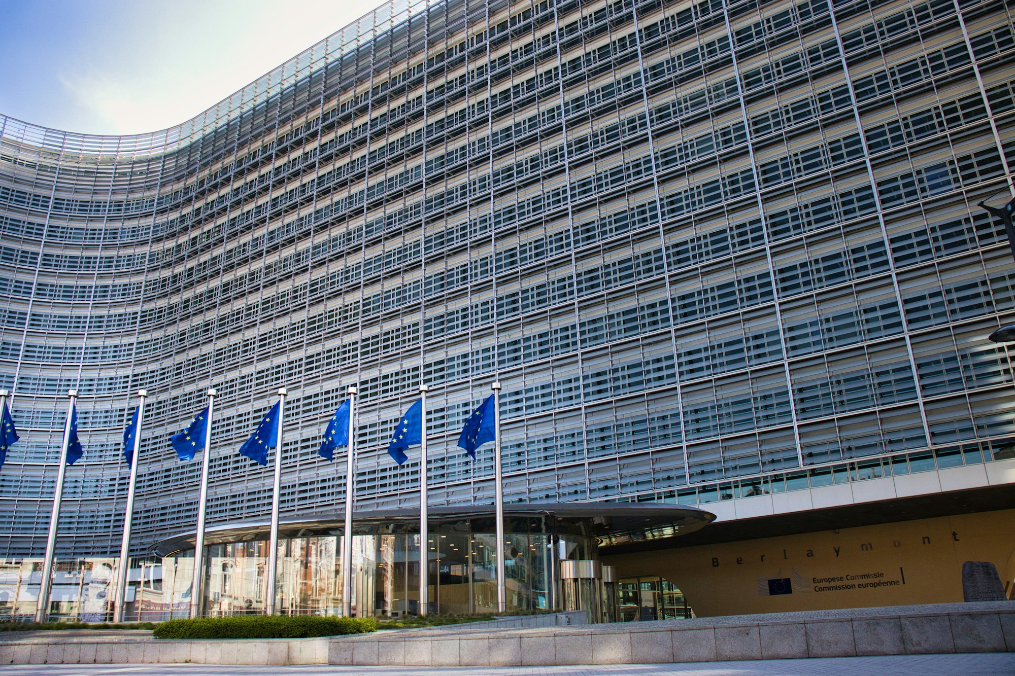 Modernes Glasgebäude mit EU-Flaggen in Brüssel, Sitz der europäischen Institutionen