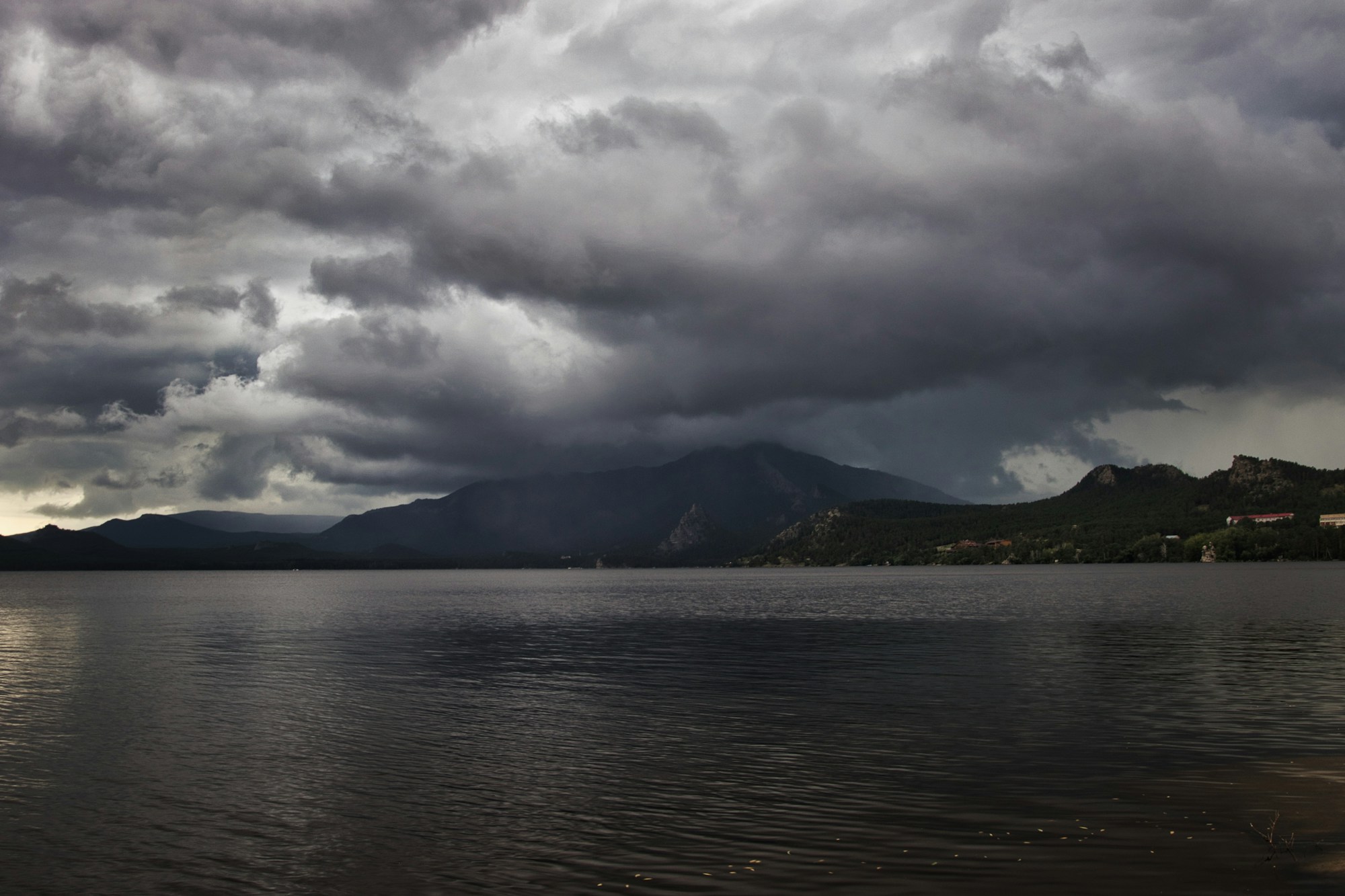 Gewitterhimmel über einem See und Bergen