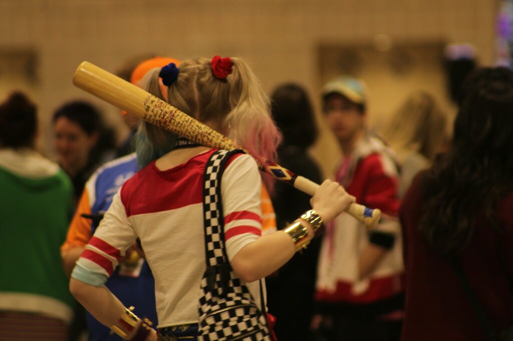 Cosplayeuse en costume de super-heroine saluant la foule lors d'une convention de pop culture