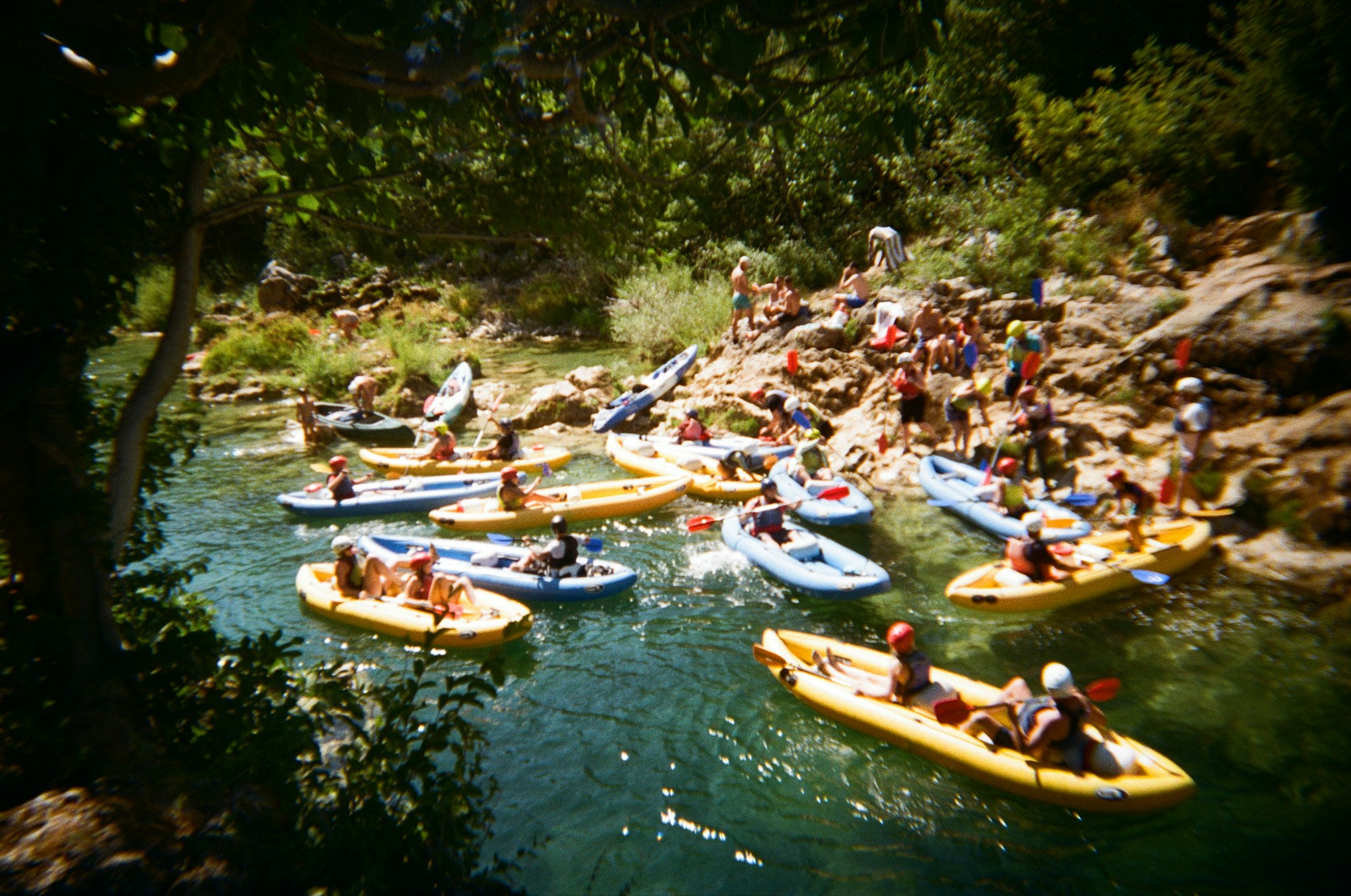 Gruppe von Kajakfahrern beim Paddeln auf einem Fluss