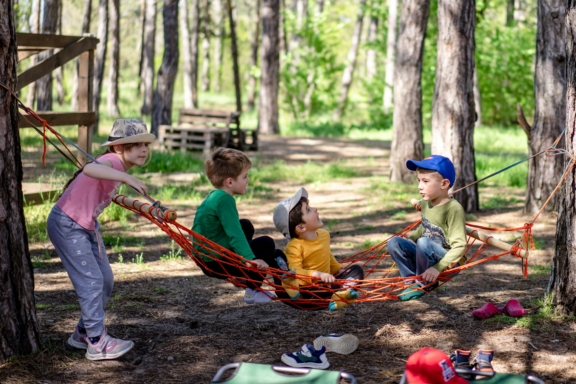 Niños instalados en una hamaca en el bosque, ambiente natural cerca de las zonas familiares de un festival