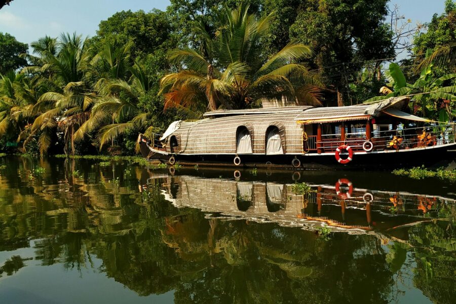 Houseboat traditionnel sur les backwaters du Kerala, bordés de palmiers