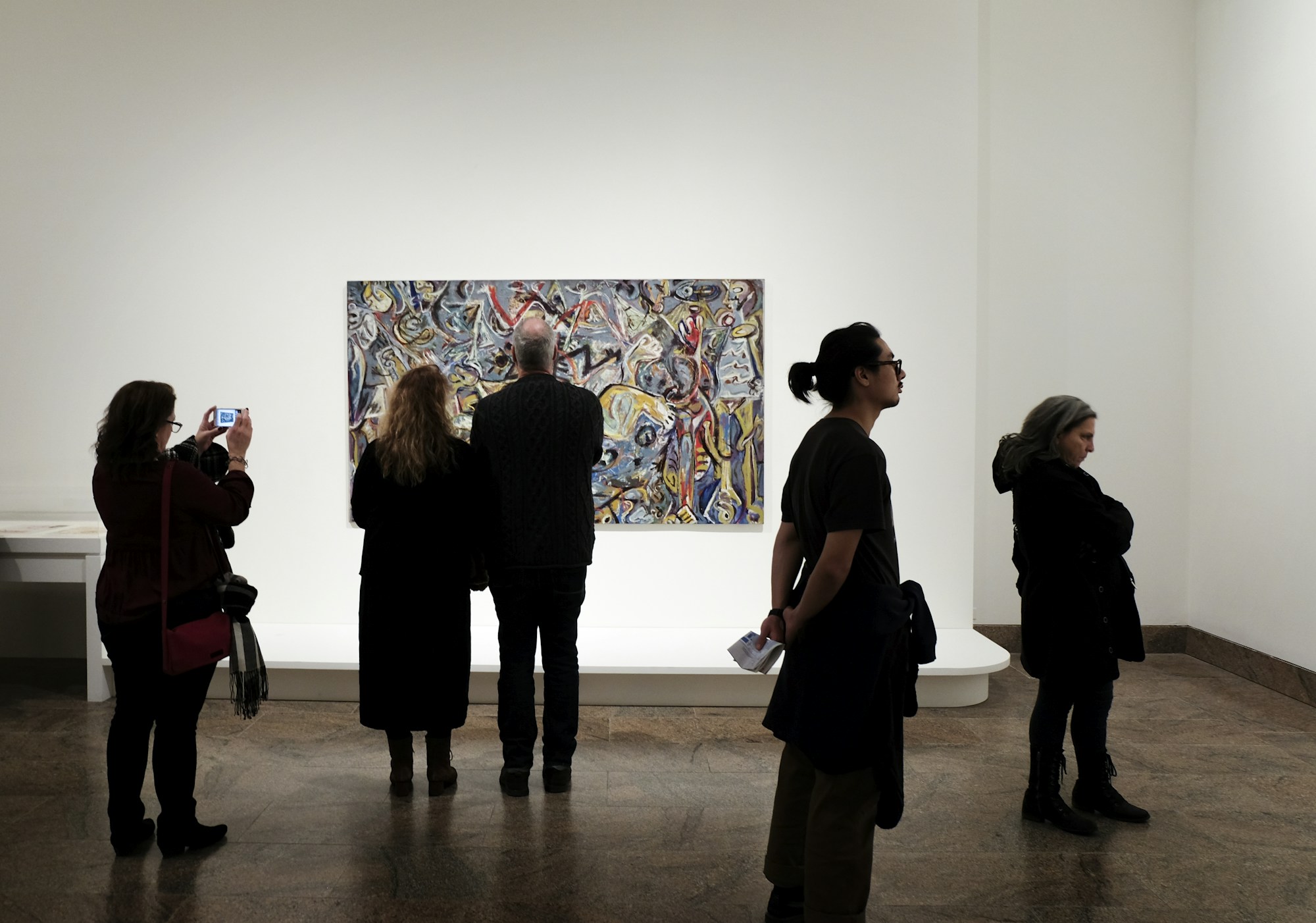 Visiteurs devant une œuvre dans une galerie d'art pendant un vernissage