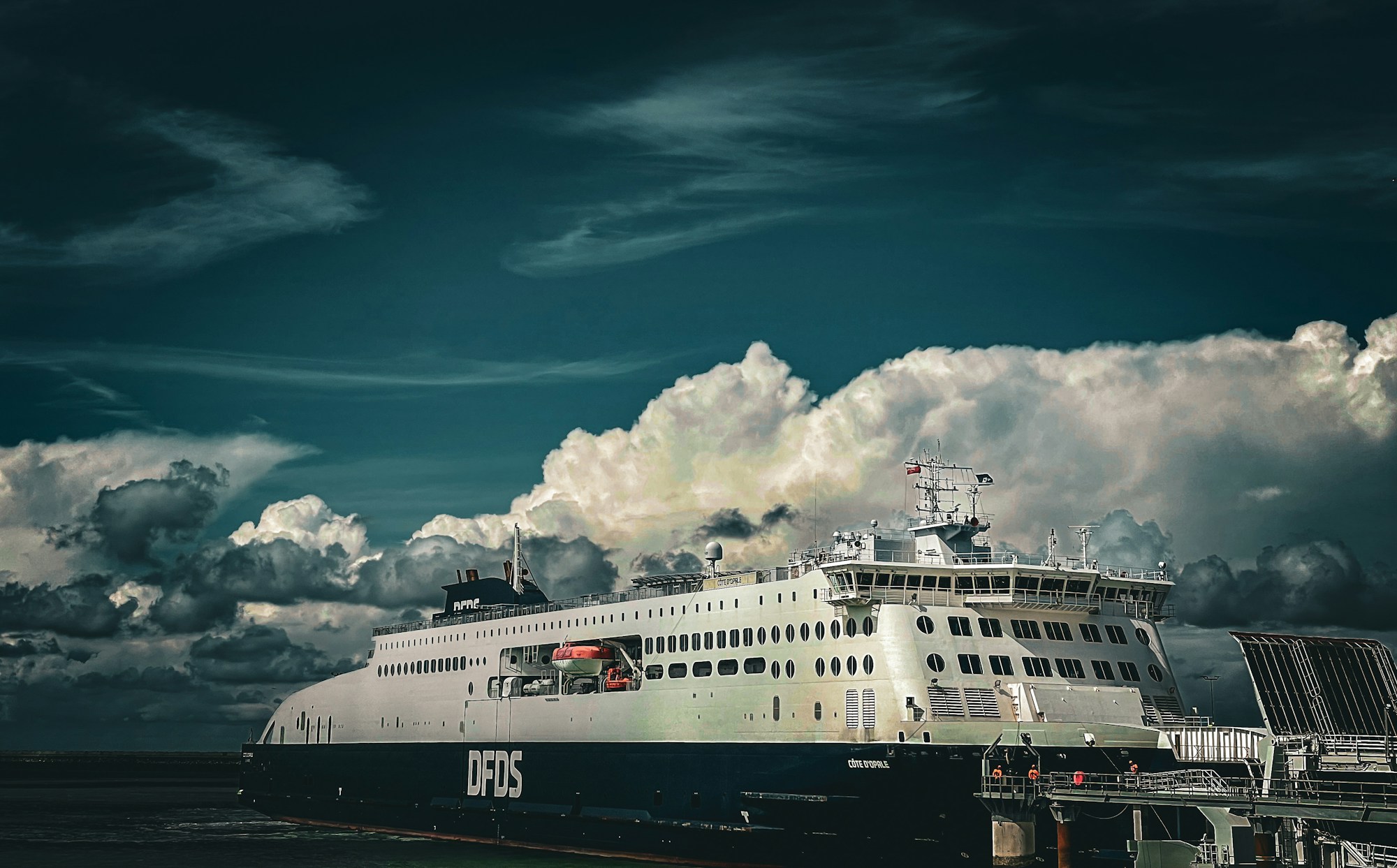 Ferry traversant la Manche vers l'Angleterre sous un ciel couvert