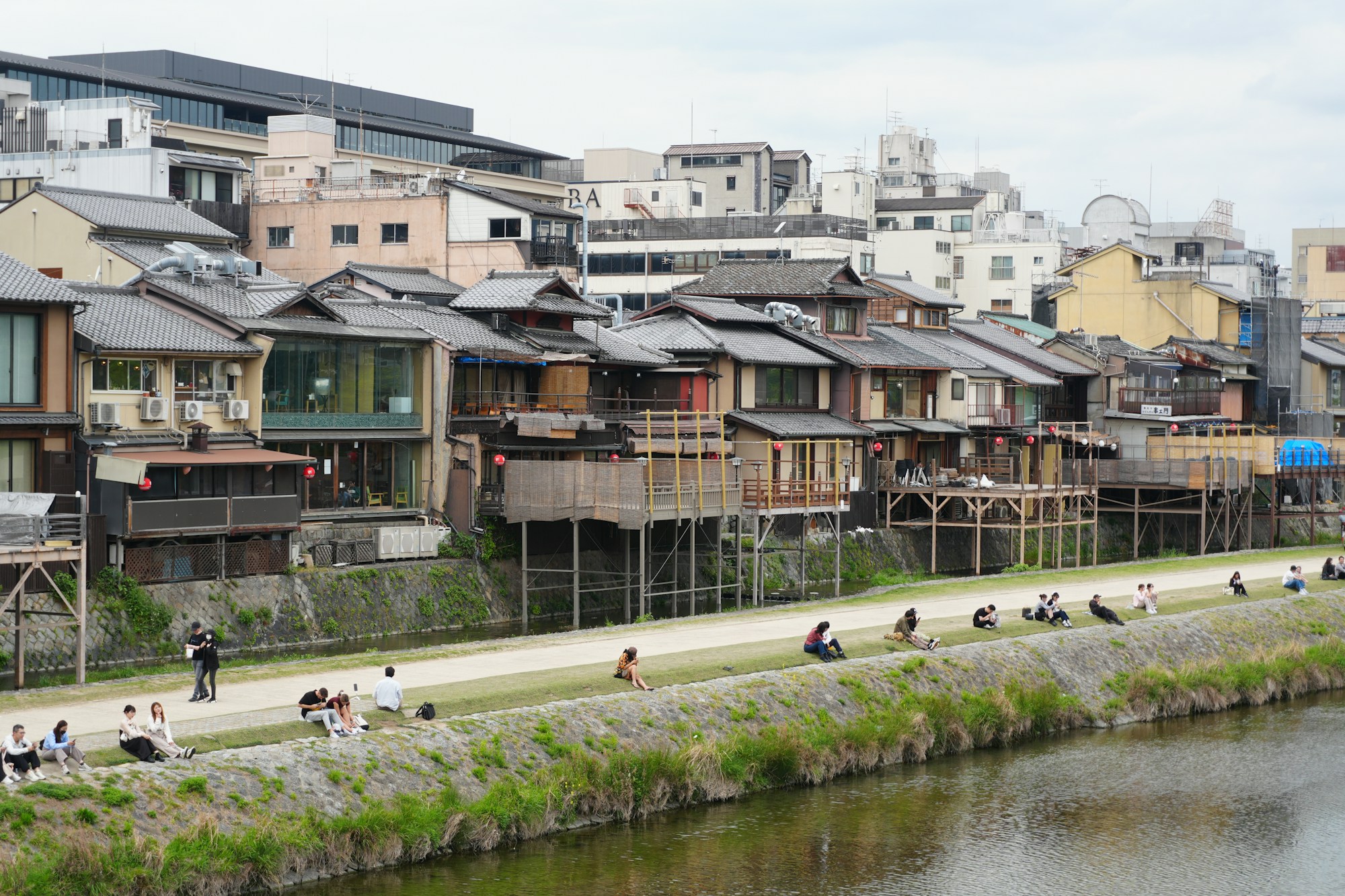 Banks of the Kamogawa river in Kyoto at dusk, a lively riverside district