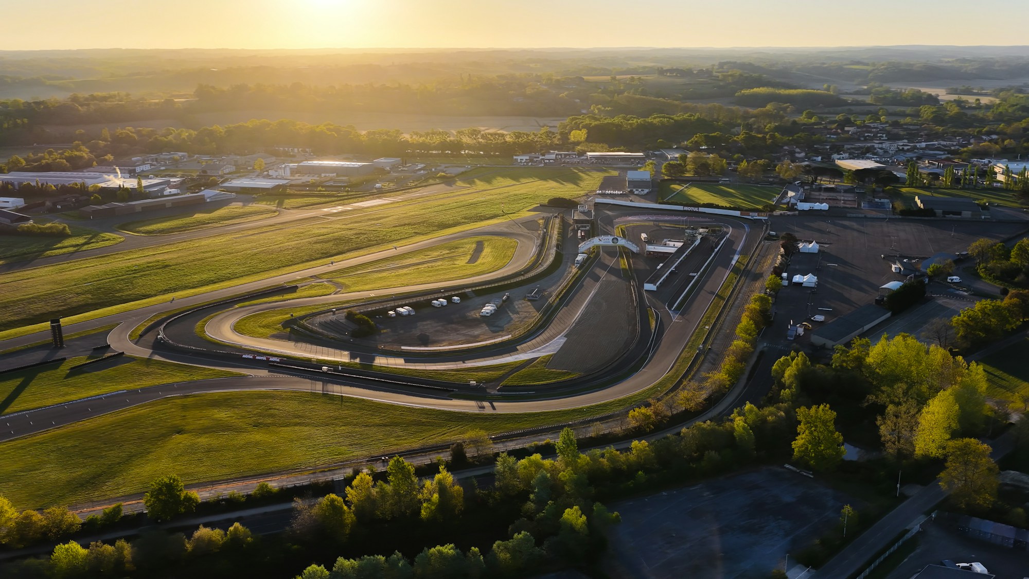 Vista aérea de un circuito de automovilismo al amanecer con sus tribunas