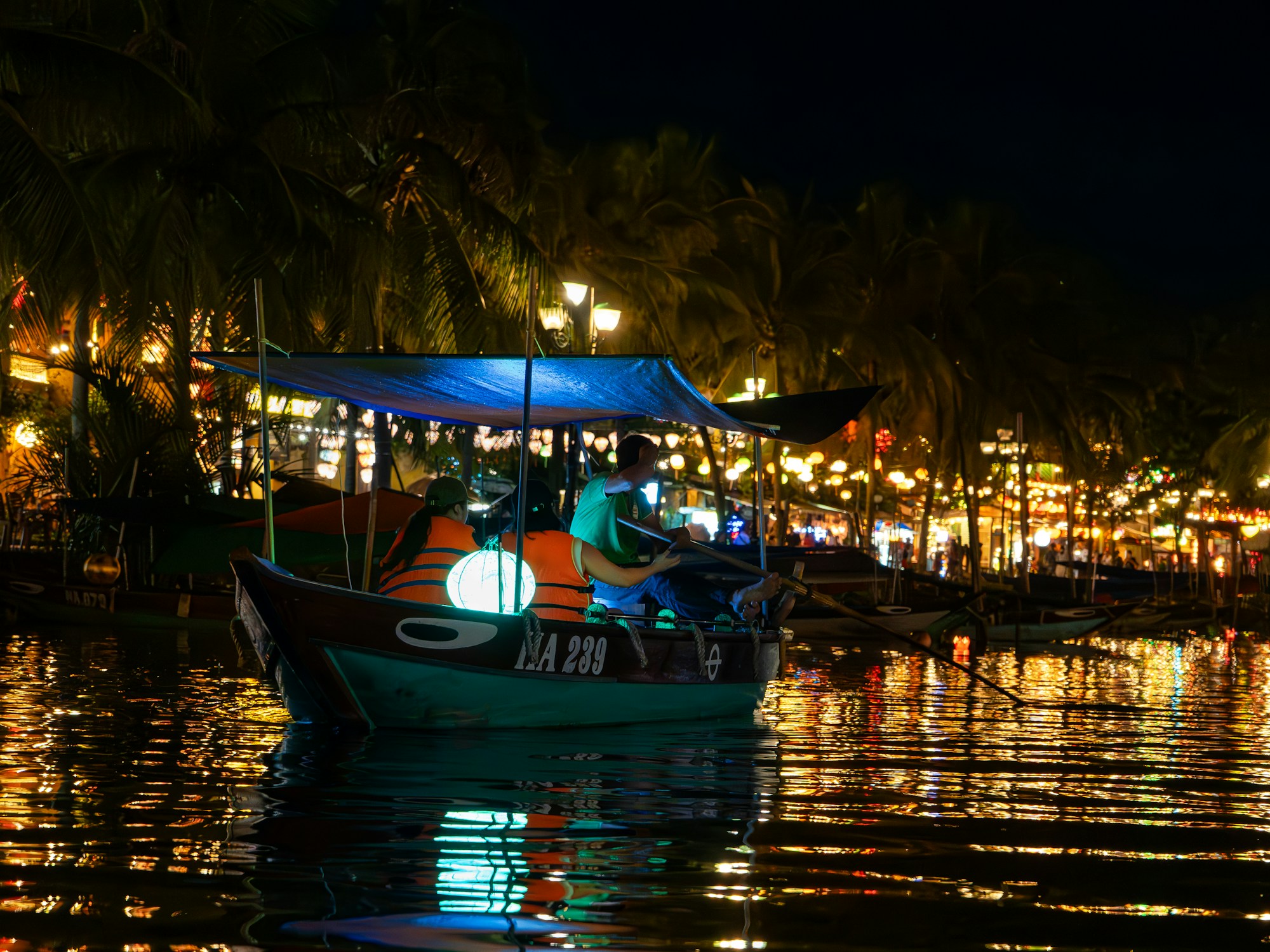 Hölzernes Boot mit Laternen auf dem Thu-Bon-Fluss in Hoi An bei Nacht