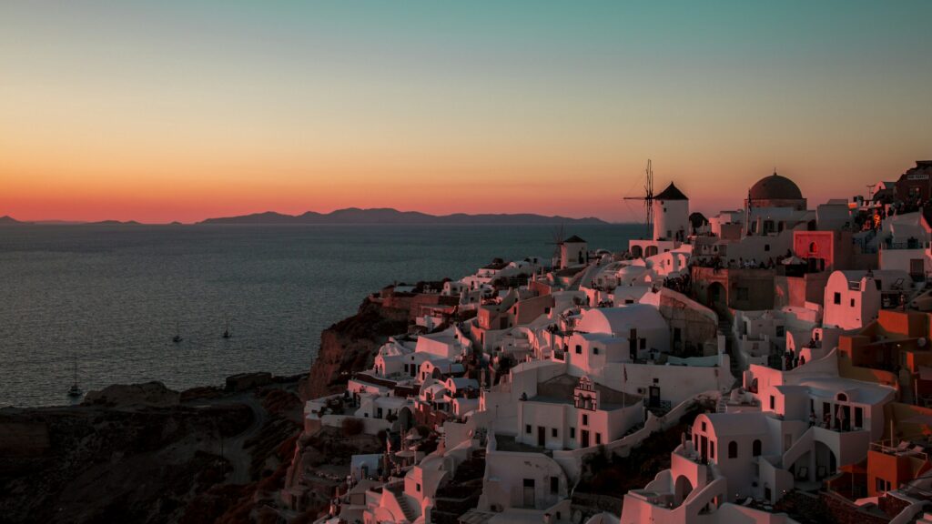 Catamaran au coucher du soleil face à la caldeira de Santorin
