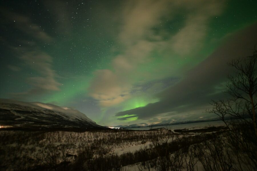 Aurore boréale verte et violette au-dessus des montagnes enneigées d'Abisko, en Laponie suédoise