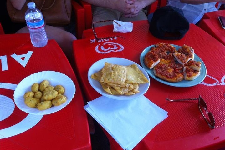 Vicolo animato dei vecchi mercati di Palermo durante la passeggiata street food