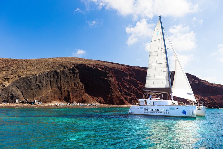 Catamaran departing from Vlychada Marina in Santorini with caldera views