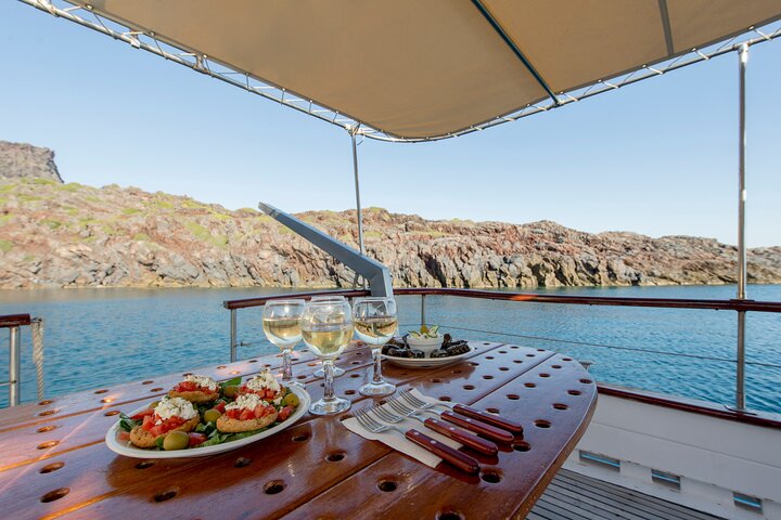 Traditional wooden Greek caïque sailing in the Santorini caldera