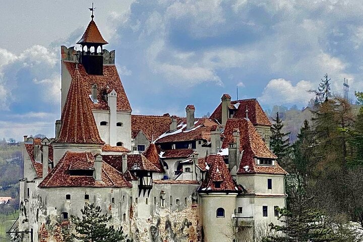 Castello di Bran arroccato sulla roccia in Transilvania, torri bianche e tetti rossi