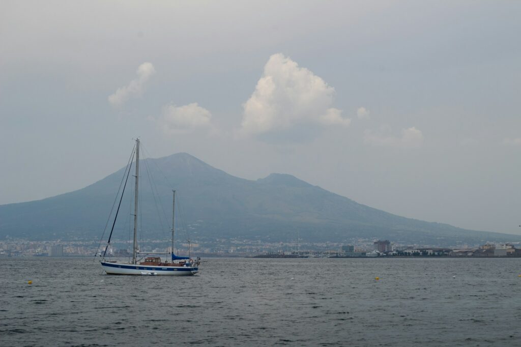 Voiliers dans le golfe de Naples au coucher du soleil, avec le Vesuve en arriere-plan
