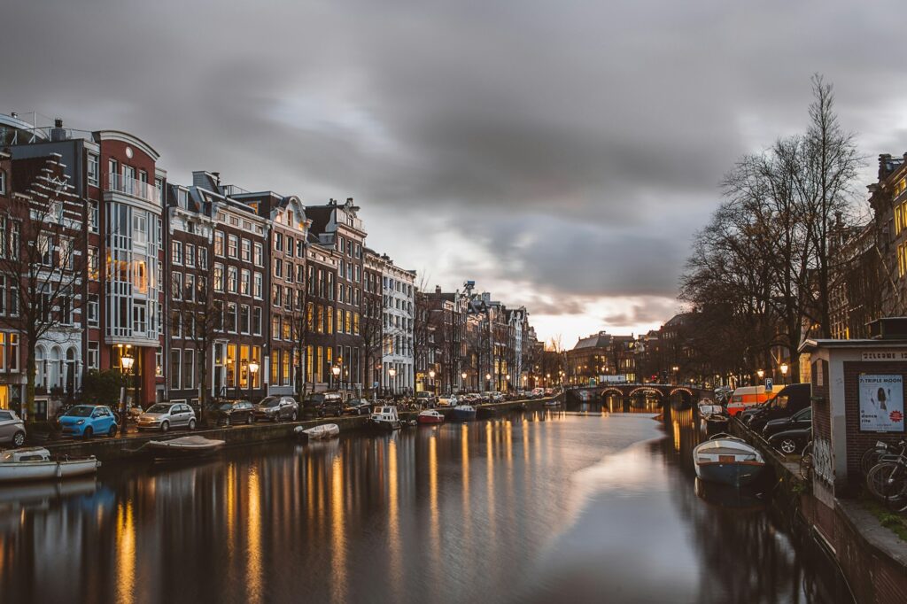 Canal bordé de maisons historiques à Amsterdam au crépuscule