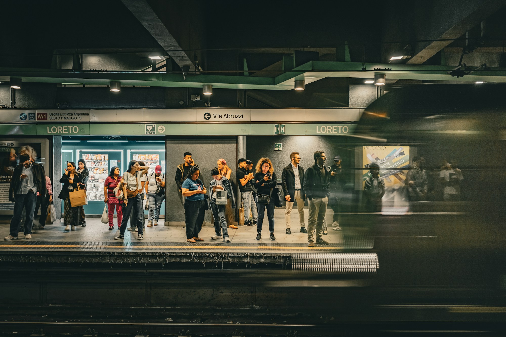 Andén de metro en Milán con viajeros esperando la llegada de un tren