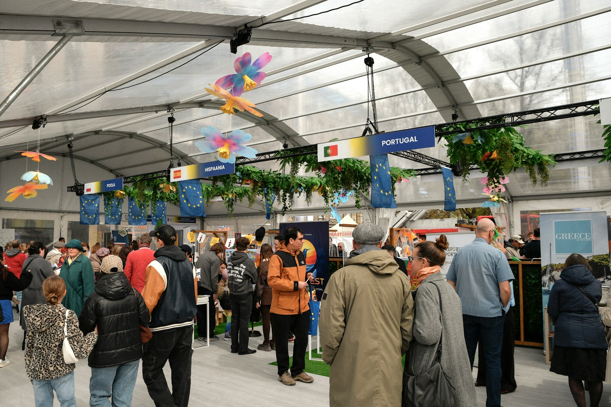 Pabellón de exposición animado con stands de países y visitantes, ambiente de feria internacional