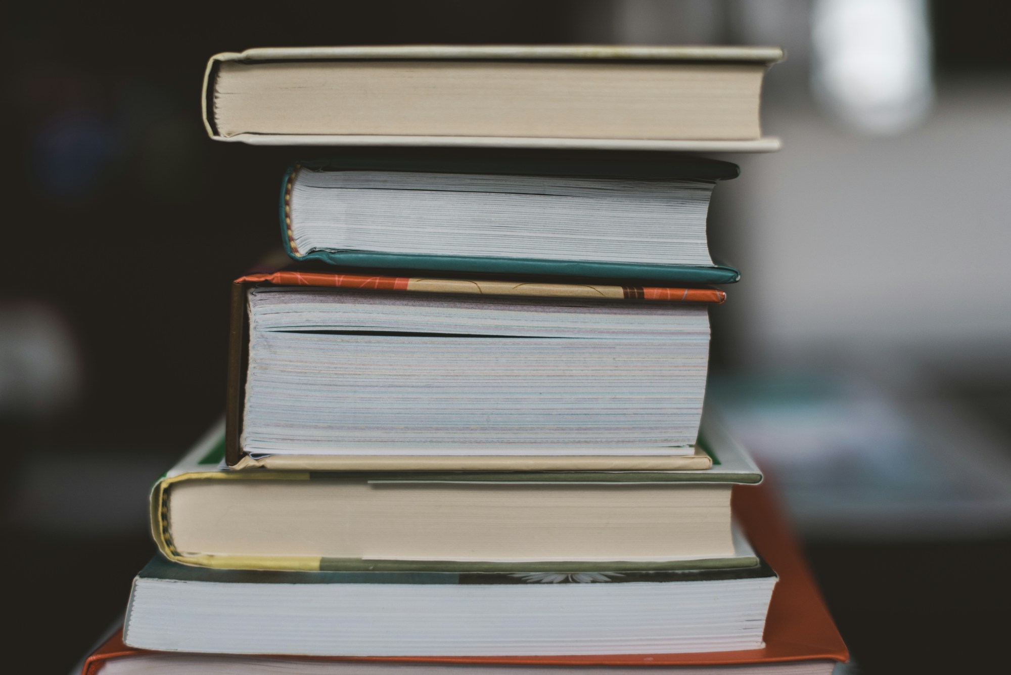 Pilas de libros cuidadosamente ordenadas, ambiente de feria y firmas de ejemplares