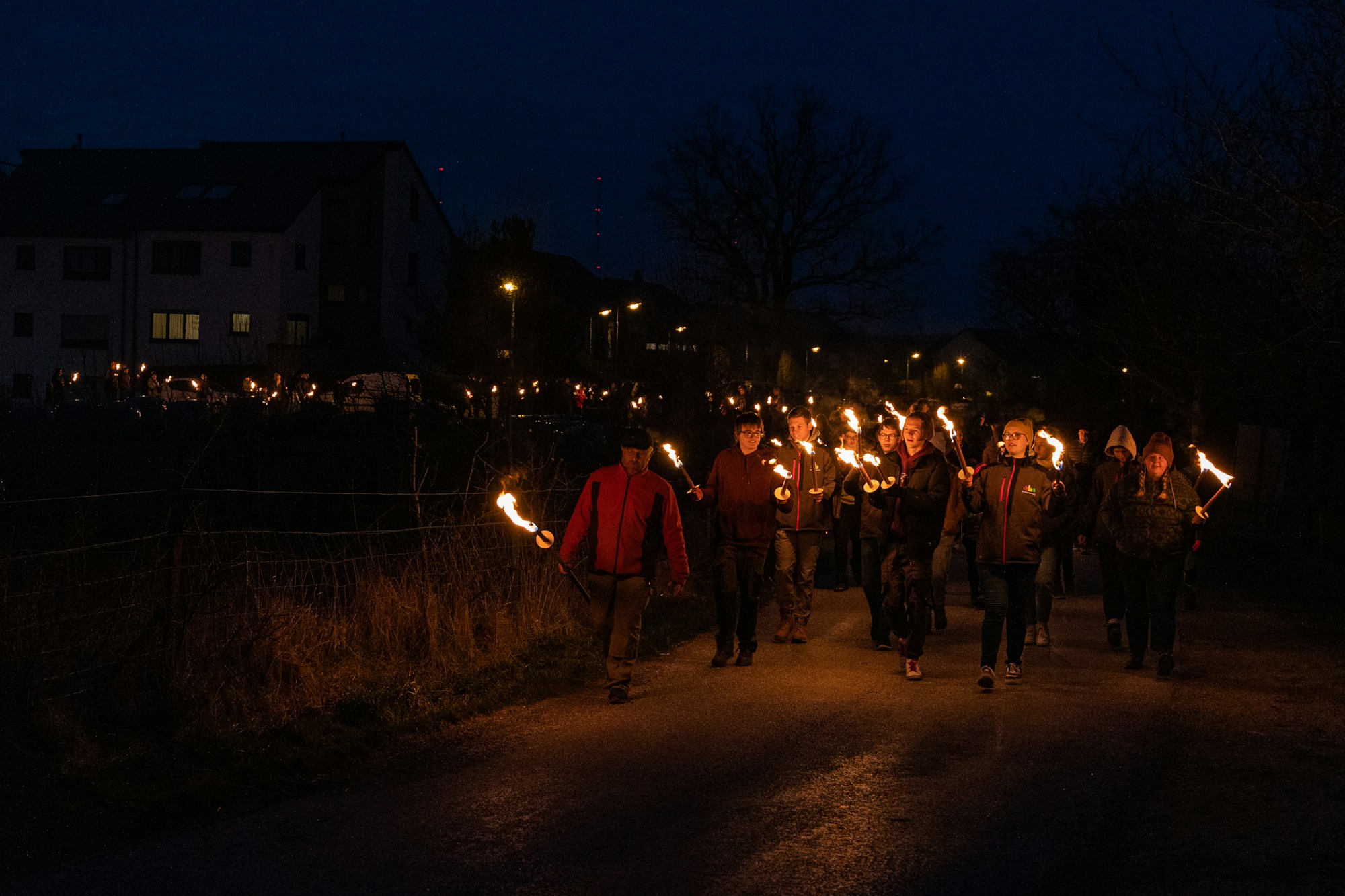 Procesión nocturna con antorchas y chispas, ambiente de correfoc