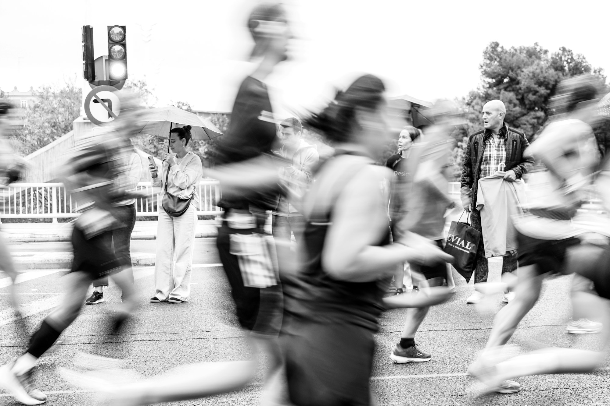 Corridori sfocati che passano davanti agli spettatori lungo una strada durante una maratona