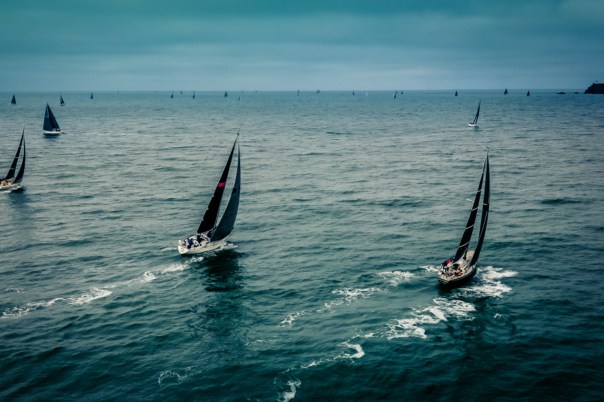 Veliero da regata a vele spiegate, mare mosso al largo