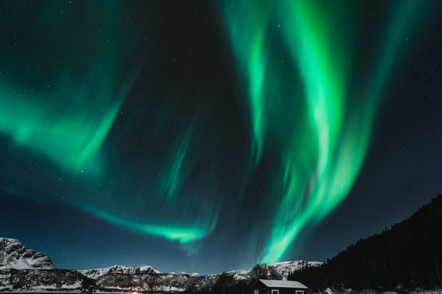 Aurores boréales vertes dans un ciel de nuit polaire au-dessus des montagnes