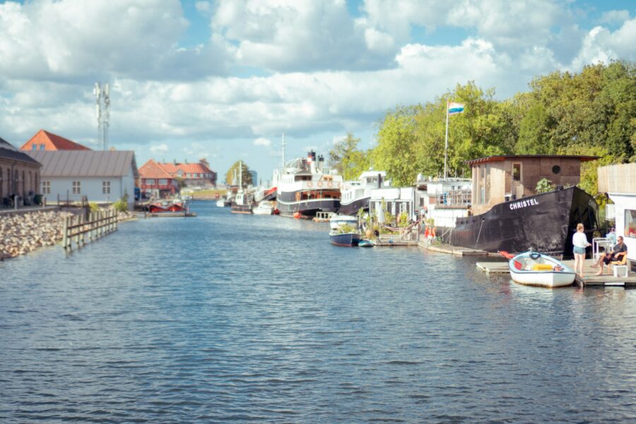 Un canal de Copenhague bordé de maisons colorées et de bateaux amarrés, en été