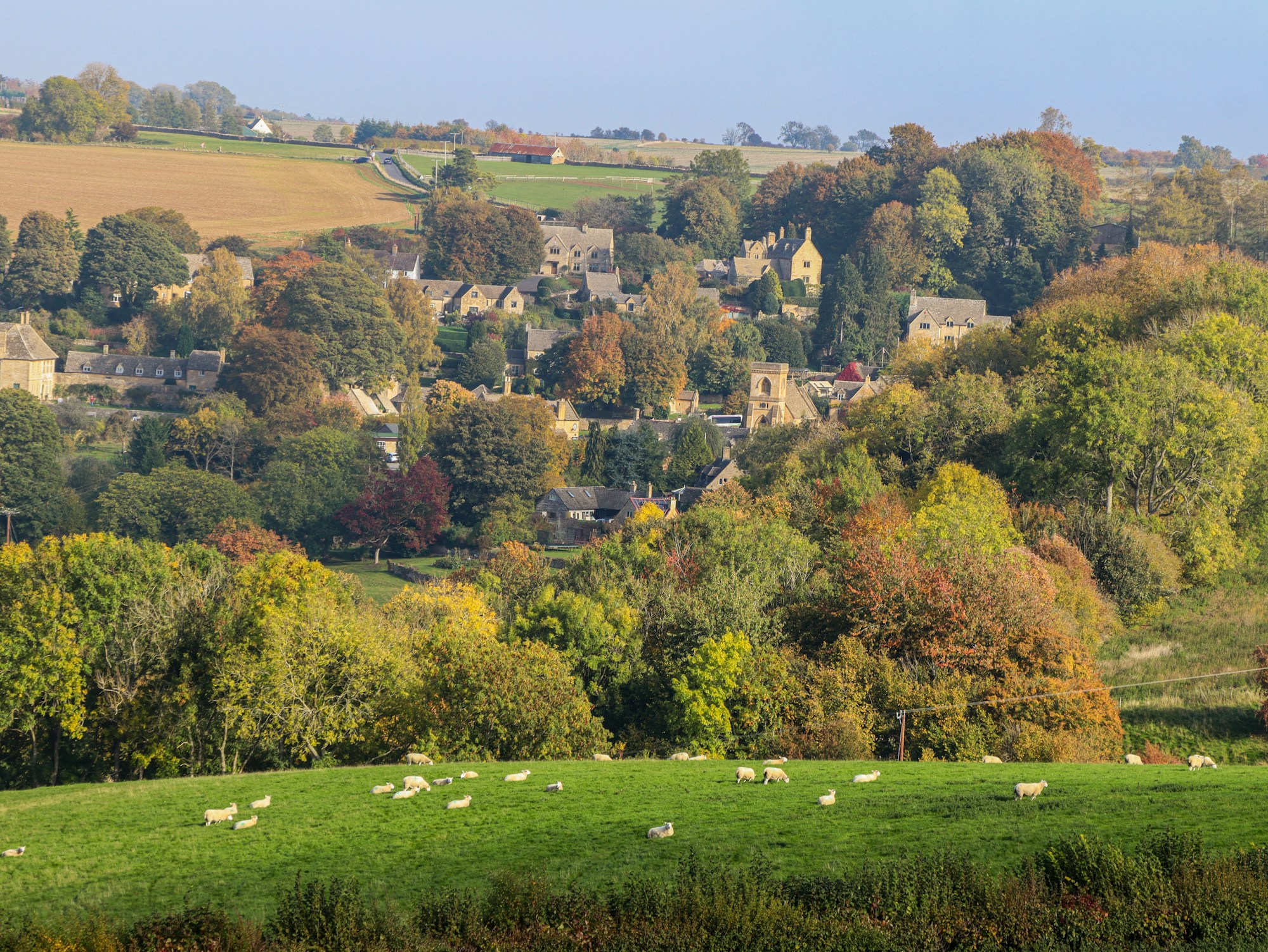 Dorf in den Cotswolds, umgeben von Wiesen in der englischen Landschaft