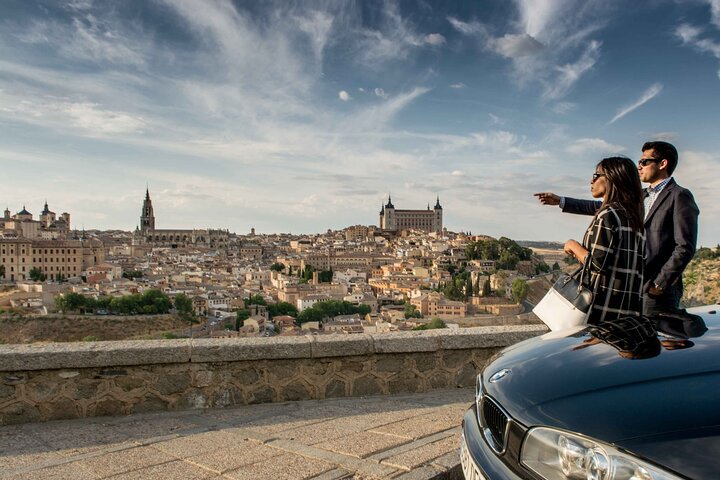 Callejuela empedrada del casco histórico de Toledo con un guía y dos visitantes