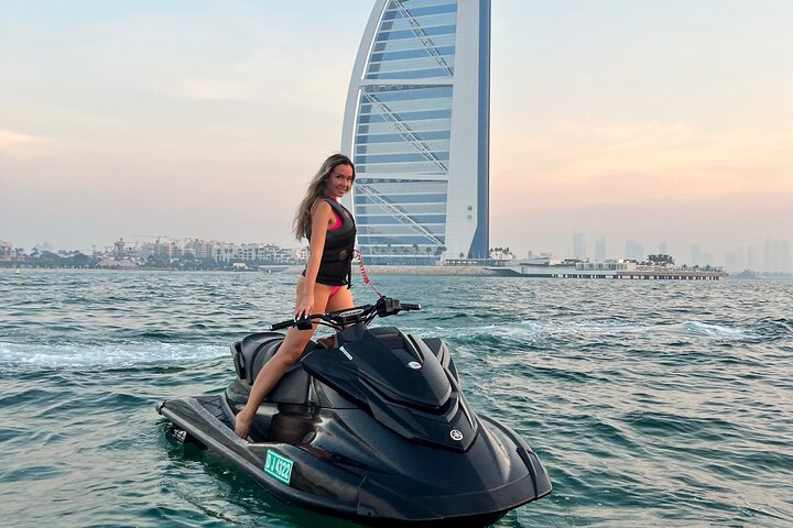 Jet ski speeding past the Burj Al Arab hotel on the Arabian Sea in Dubai