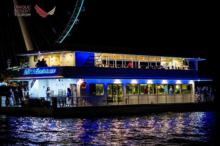 Illuminated catamaran at sunset on the Dubai Marina canal