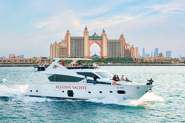 Luxury yacht sailing past Dubai Marina skyscrapers at the end of the day