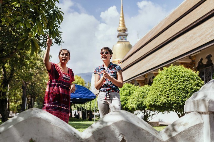 Guide local et visiteuse devant un temple de Chiang Mai lors d'une visite privée